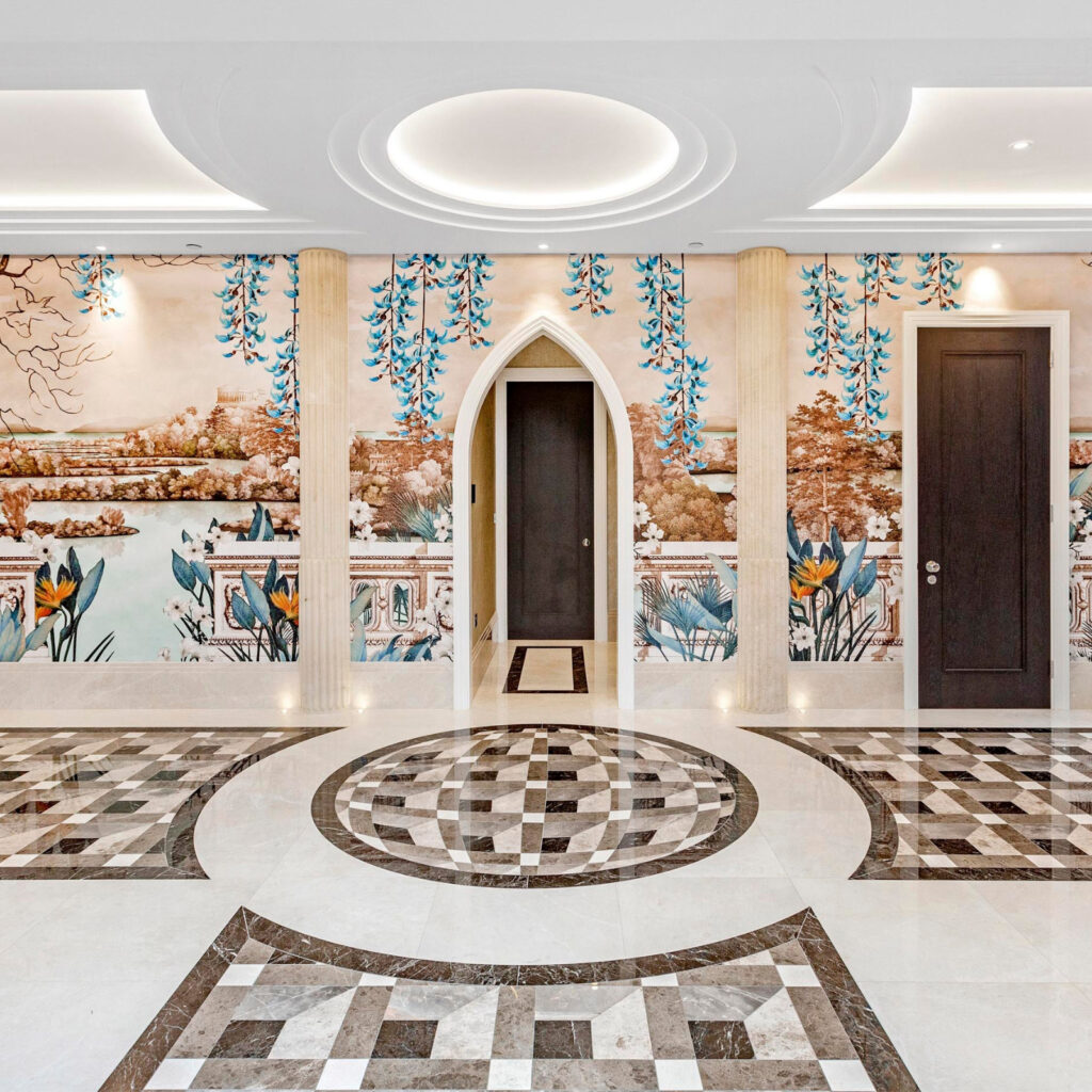 Bright hallway with bespoke ceiling moulding, black and white marble flooring, and custom scenic wall mural inspired by classical design.