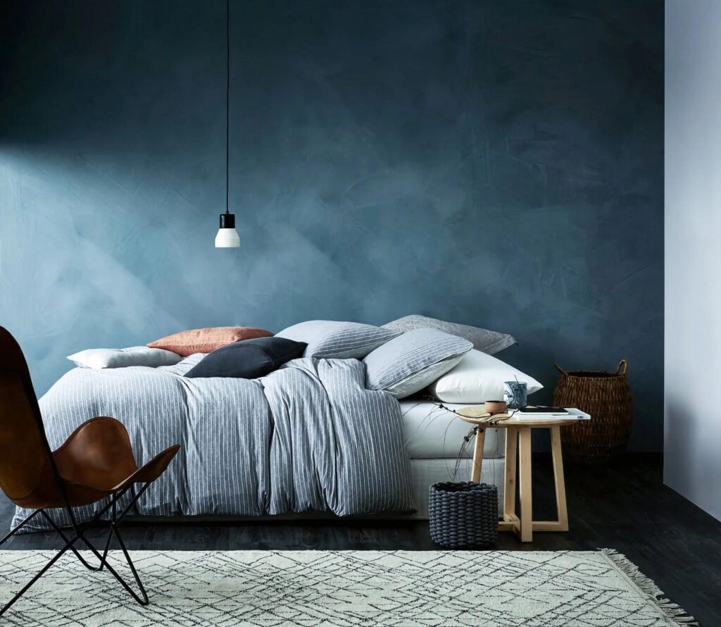 Moody interior painted in Bauwerk’s Nest limewash, evoking twilight skies with deep indigo tones, paired with velvet furnishings and grounding neutral accents.